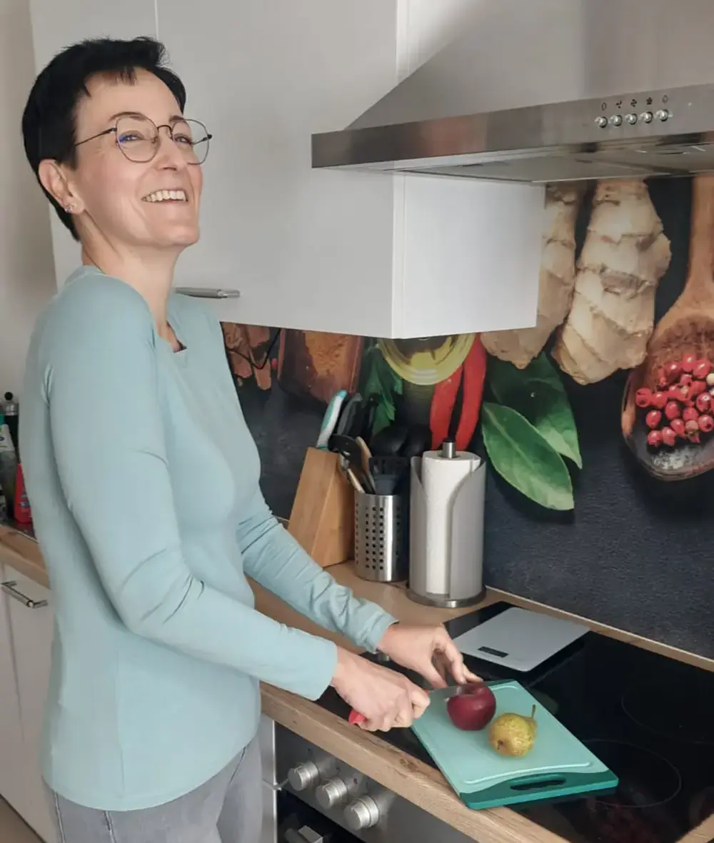 Asiatische Frau hackt Gemüse in der Küche für gesunde Mahlzeit Vorbereitung